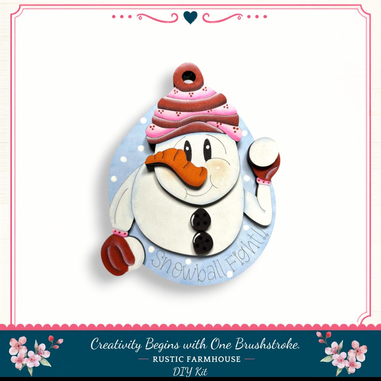 A snowman ornament with a red and white striped hat, holding a snowman ball, and the text "Snowball Fight!" is displayed against a white background.