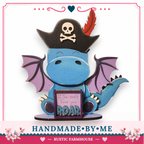 A handcrafted wooden dragon statue with a pirate hat and a sign that says "It's the world, hear you roar".