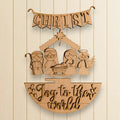 A wooden nativity scene with a banner that says "CHRIST" and the phrase "Joy to the world" below it.
