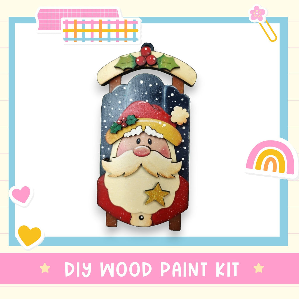 a DIY wood paint kit for creating a wooden ornament resembling a Christmas-themed character, such as Santa Claus.