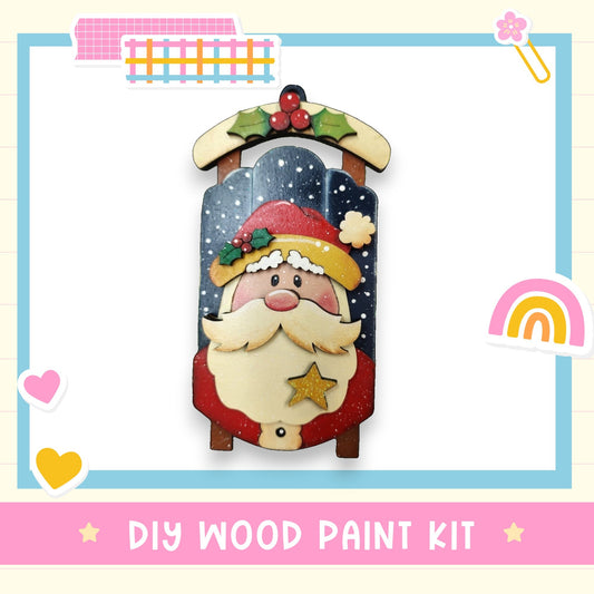 a DIY wood paint kit for creating a wooden ornament resembling a Christmas-themed character, such as Santa Claus.