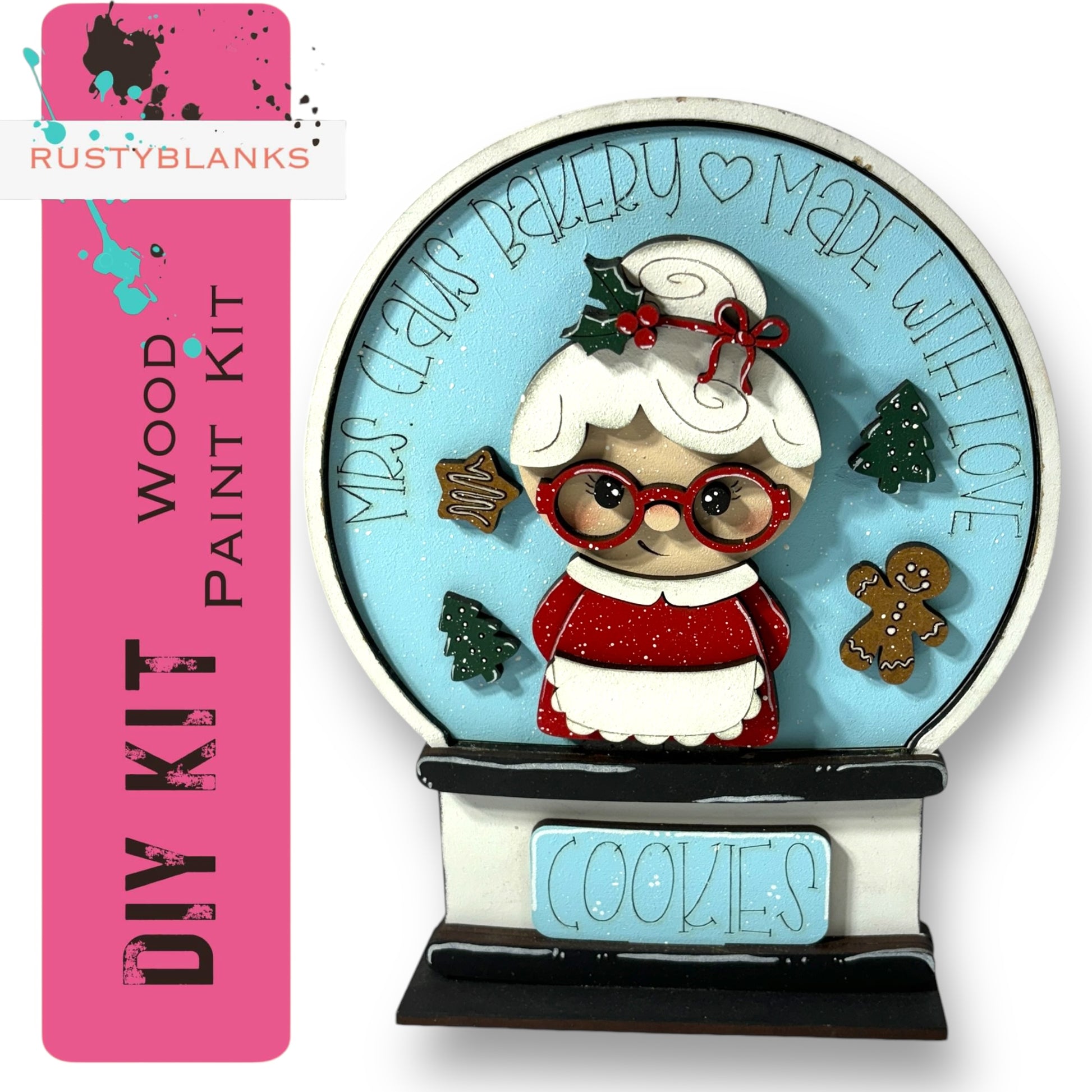 A DIY paint kit for creating a wooden snow globe with a picture of a woman, cookies, and other holiday decorations.