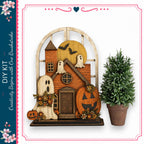 a Halloween-themed wooden house decoration with a carved pumpkin, ghost, and other spooky elements. The decoration is displayed next to a potted plant, creating a festive atmosphere.