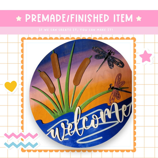 a picture of a welcome sign with dragonflies