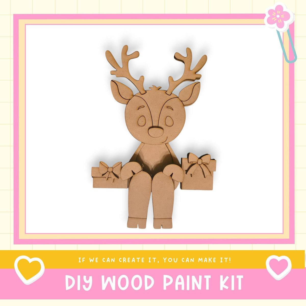 A wooden deer figurine holding a gift box, with a pink and white border and text promoting a DIY wood paint kit.