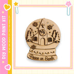 A wooden snow globe with a church and snowflakes, along with the text "Peace on Earth" on the base.
