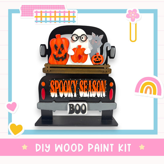 A Halloween-themed DIY wood paint kit featuring a spooky truck with a ghost, jack-o-lanterns, and a cat.