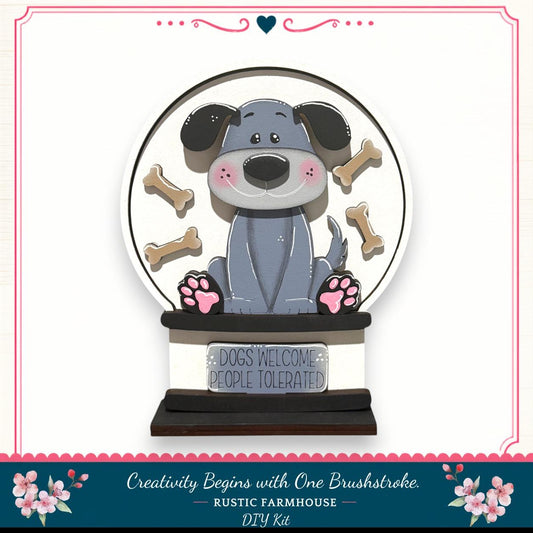 A wooden snow globe featuring a cartoon dog surrounded by dog bones, with a sign that says "Dogs Welcome People Tolerated".