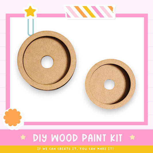 two wooden paint kits, one larger and one smaller, with a pink and white background and a star decoration.