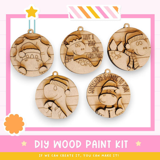 a DIY wood paint kit with five wooden ornaments, each with a unique design and text. The kit appears to be a creative project for crafting wooden ornaments, as indicated by the text "DIY WOOD PAINT KIT" and "IF WE CAN CREATE IT, YOU CAN MAKE IT!"