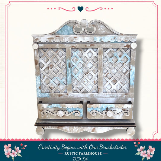 a rustic farmhouse-style wooden cabinet with a decorative lattice design and two drawers. The cabinet has a distressed, weathered appearance, suggesting it has been well-used and loved over time. The text "Creativity Begins with One Brushstroke. Rustic Farmhouse - DIY Kit" indicates that this cabinet is part of a DIY kit for creating a similar piece of furniture.