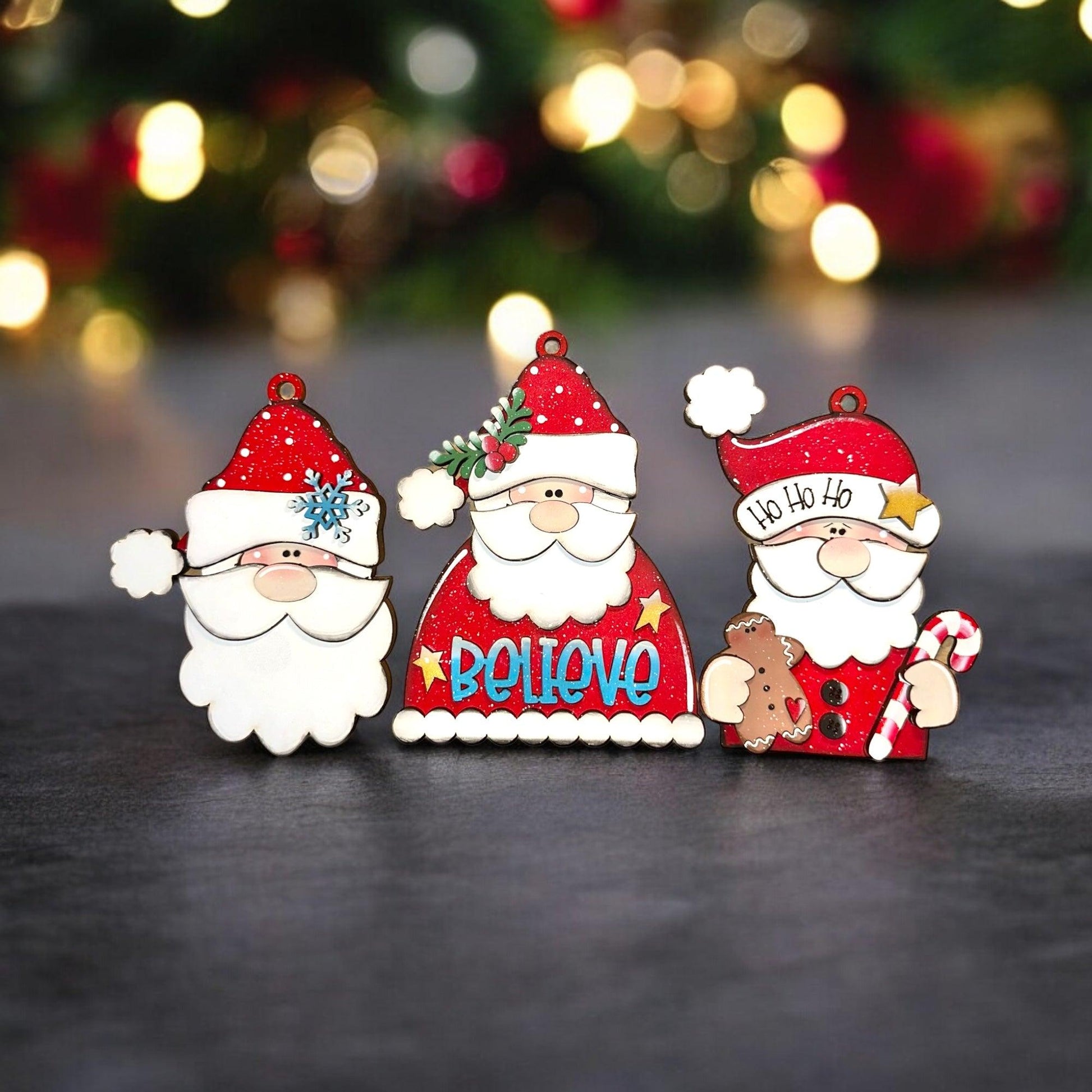 a couple of santa clause figurines sitting next to a christmas tree