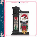 a black clock with a Santa Claus figure hanging from it, along with a Christmas tree and other holiday-themed decorations.