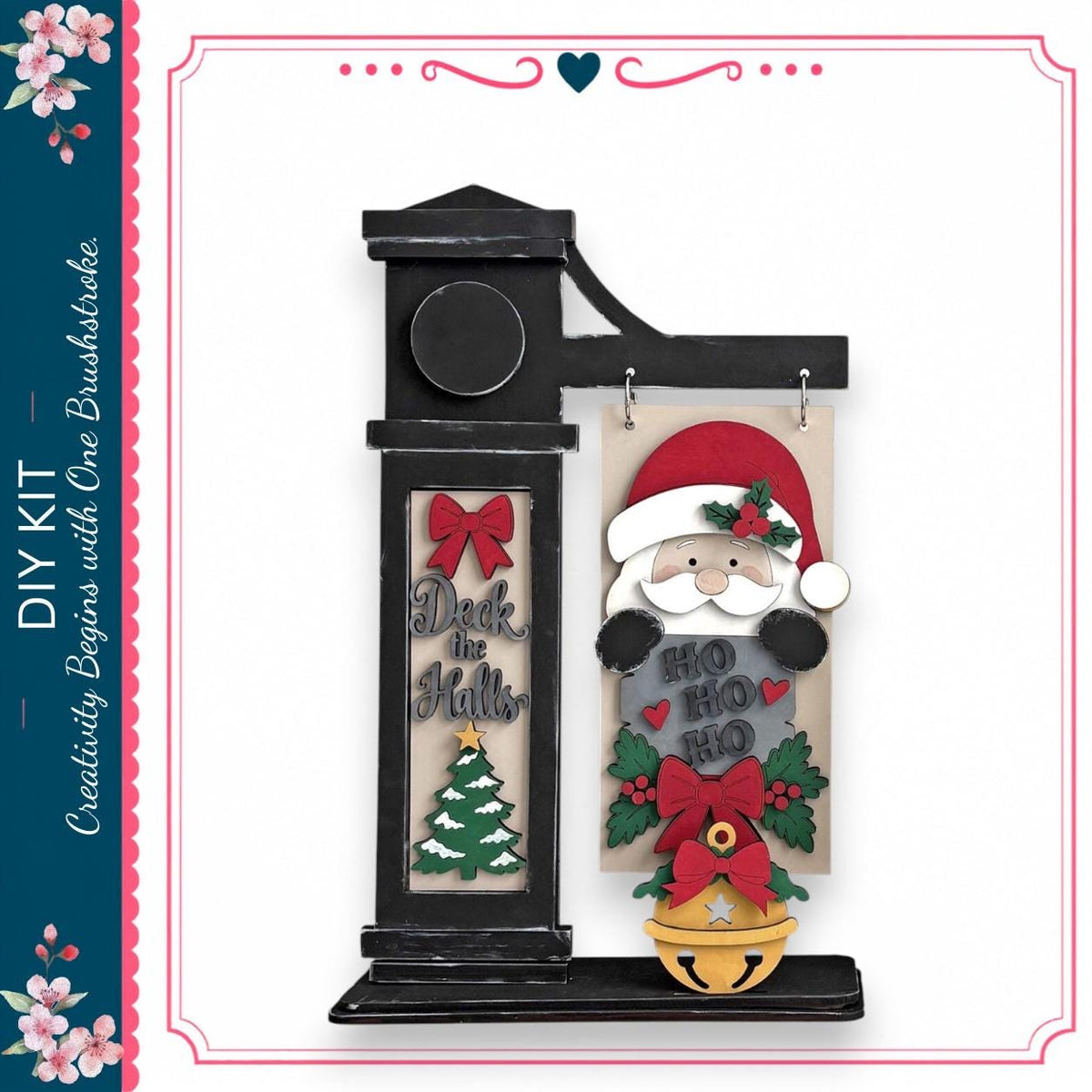 a black clock with a Santa Claus figure hanging from it, along with a Christmas tree and other holiday-themed decorations.
