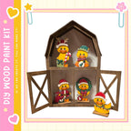 A wooden barn-shaped display case containing four small duck figurines, each wearing a unique hat and scarf, arranged inside the open barn.