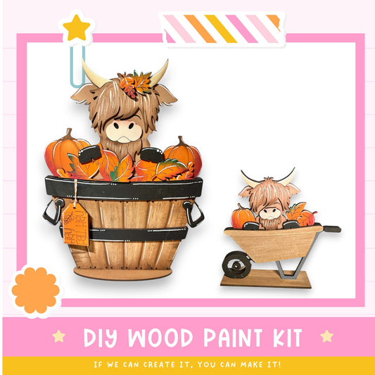 a DIY wood paint kit with a wooden barrel and a wooden wheelbarrow, both filled with pumpkins and leaves. The kit appears to be made of wood and is designed for painting.