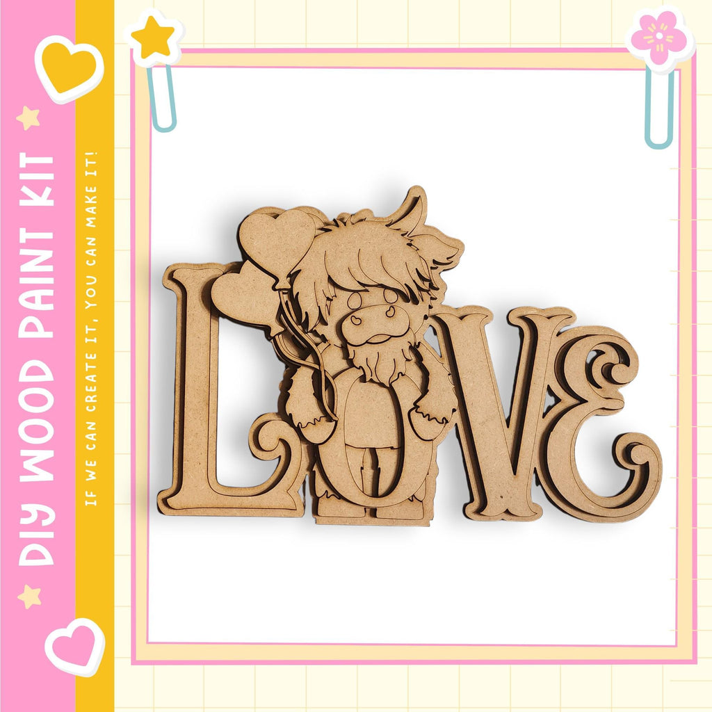 A wooden cutout of a cartoon character with a heart-shaped nose and a heart-shaped ear, set against a pink and yellow background with the text "My Wood Paint Kit" and "If we can create it, you can make it"