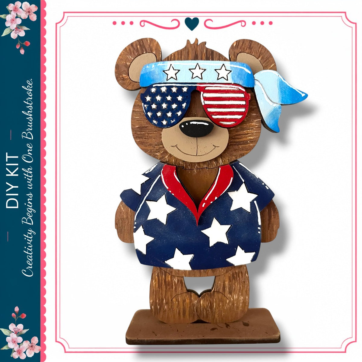A wooden teddy bear wearing sunglasses and a patriotic outfit with stars and stripes, standing on a wooden base.