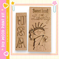two wooden cutouts of the Statue of Liberty, one with the letters "USA" carved into it and the other with the words "Sweet land of Liberty" carved into it.