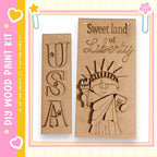 two wooden cutouts of the Statue of Liberty, one with the letters "USA" carved into it and the other with the words "Sweet land of Liberty" carved into it.