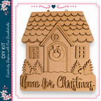 a wooden house with a wreath on the front door, surrounded by trees and bushes. The text "Home for Christmas" is displayed below the house.
