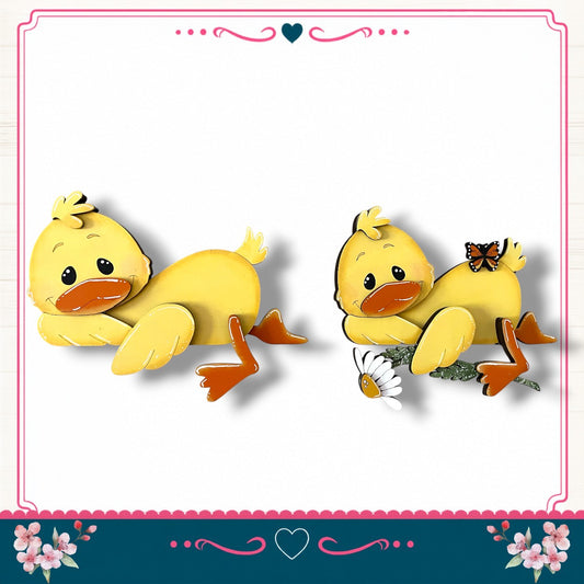 two yellow duck-shaped figures, one standing and one sitting, with flowers and a heart-shaped border surrounding them.