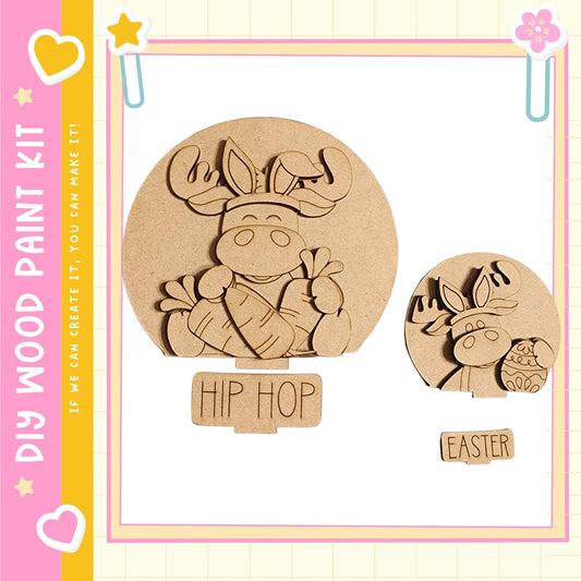 two wooden cutouts of cartoon animals, one larger and one smaller, both with the word "HIP HOP" written on them. The larger cutout is a moose, and the smaller one is a deer. The cutouts are set against a pink and yellow background with decorative elements such as hearts and stars.