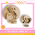 a DIY wood paint kit for creating Halloween decorations, including a skeleton and a skull. The kit appears to be made of wood and is designed for painting.