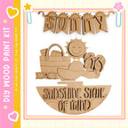The image is a collage featuring a wooden sign with the word "SUNNY" and various beach-related objects such as a sun, sunglasses, a beach bag, and a flip-flop.