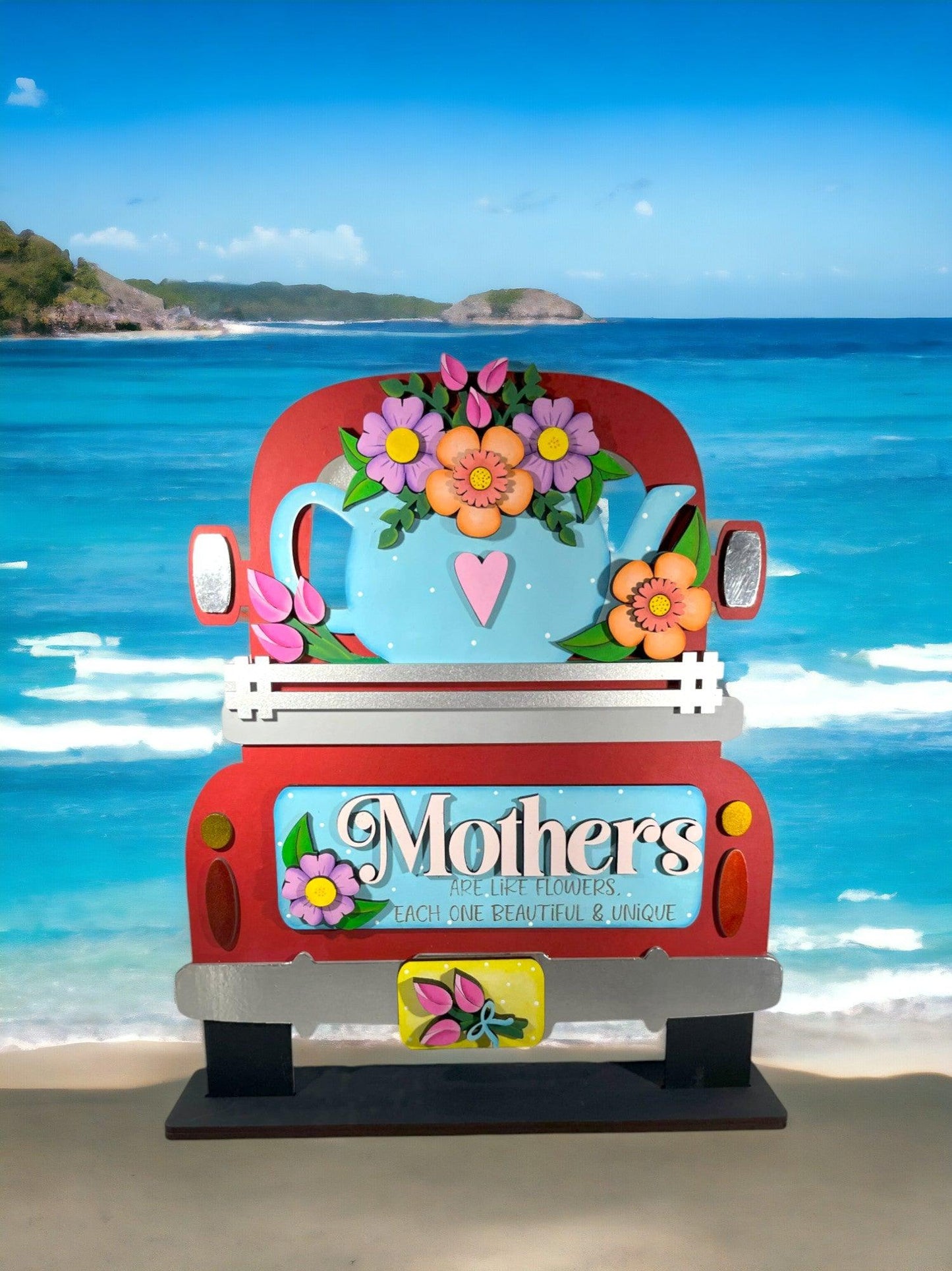 a red truck parked on top of a sandy beach