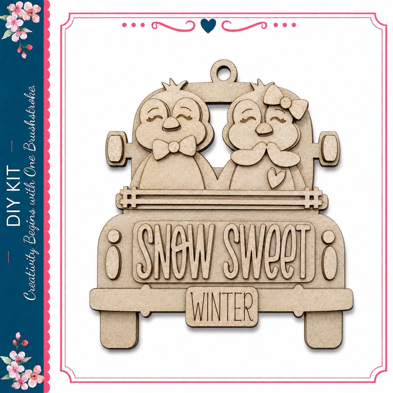 A wooden ornament depicting two cartoon penguins in a truck, with the text "SNOW SWEET WINTER" written on the back of the truck.