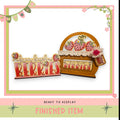 a wooden sign with the word "BERRIES" written on it, along with a basket of strawberries. The sign and basket are displayed in a pink and green frame, and the image is described as a finished item, ready to be displayed.