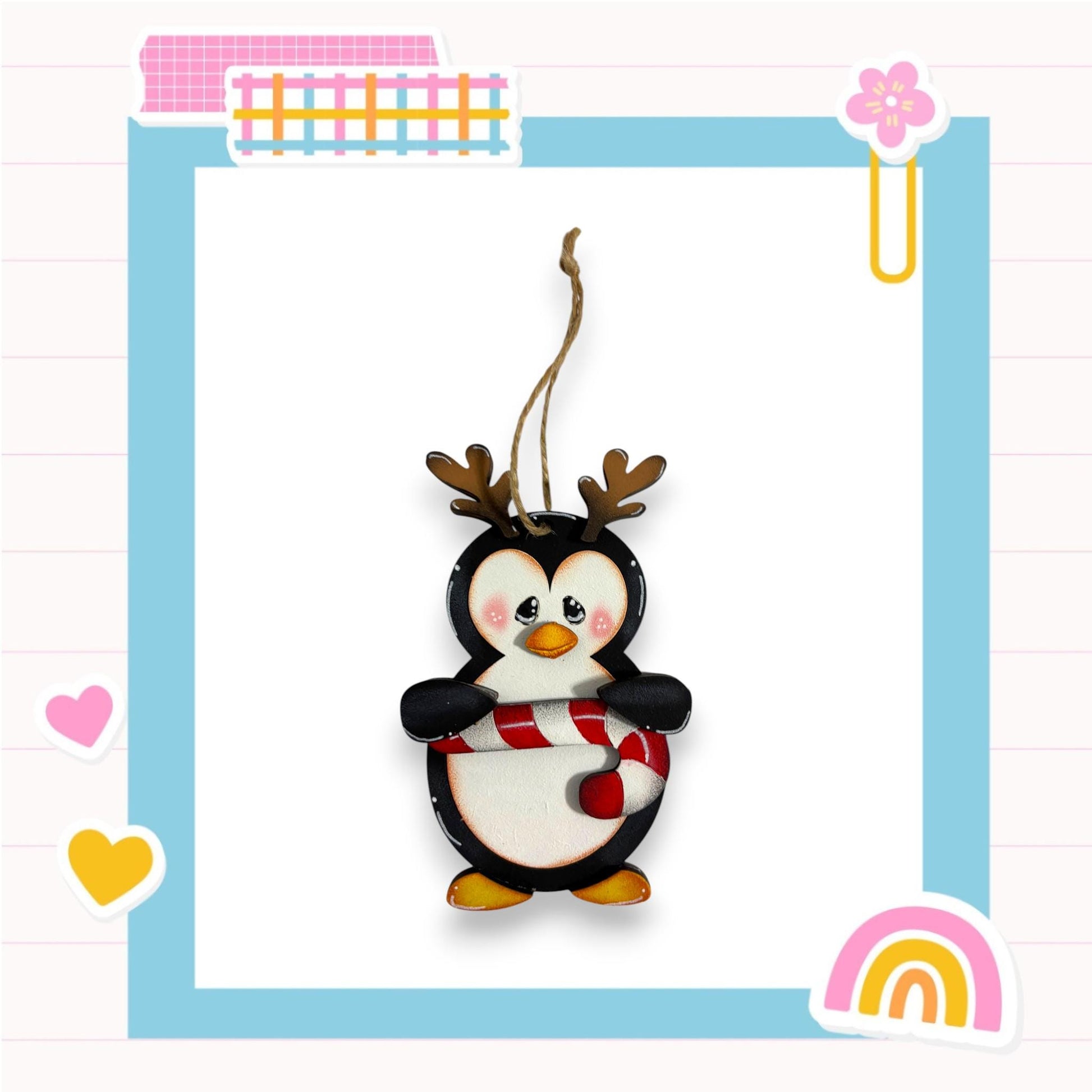 A penguin ornament with antlers is displayed in a colorful frame with various decorative elements.