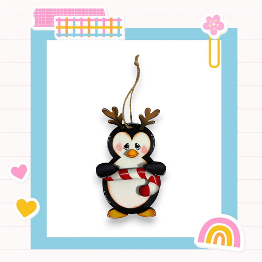 A penguin ornament with antlers is displayed in a colorful frame with various decorative elements.