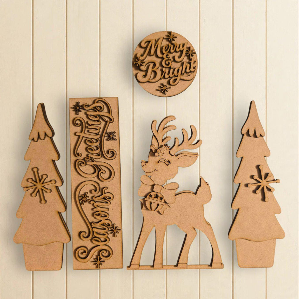 a collection of wooden cutouts, including a deer, trees, and a circular sign with the text "Merry & Bright".
