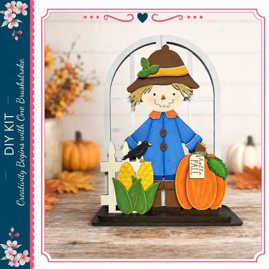 A DIY kit featuring a scarecrow figure with a pumpkin, corn, and leaves, set against a backdrop of fall decorations and a window.