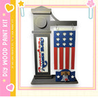 a DIY paint kit kit, which includes a wooden frame with an American flag design and a wooden plaque. The kit appears to be made of wood and is designed for creating a wooden frame with a painted American flag design.