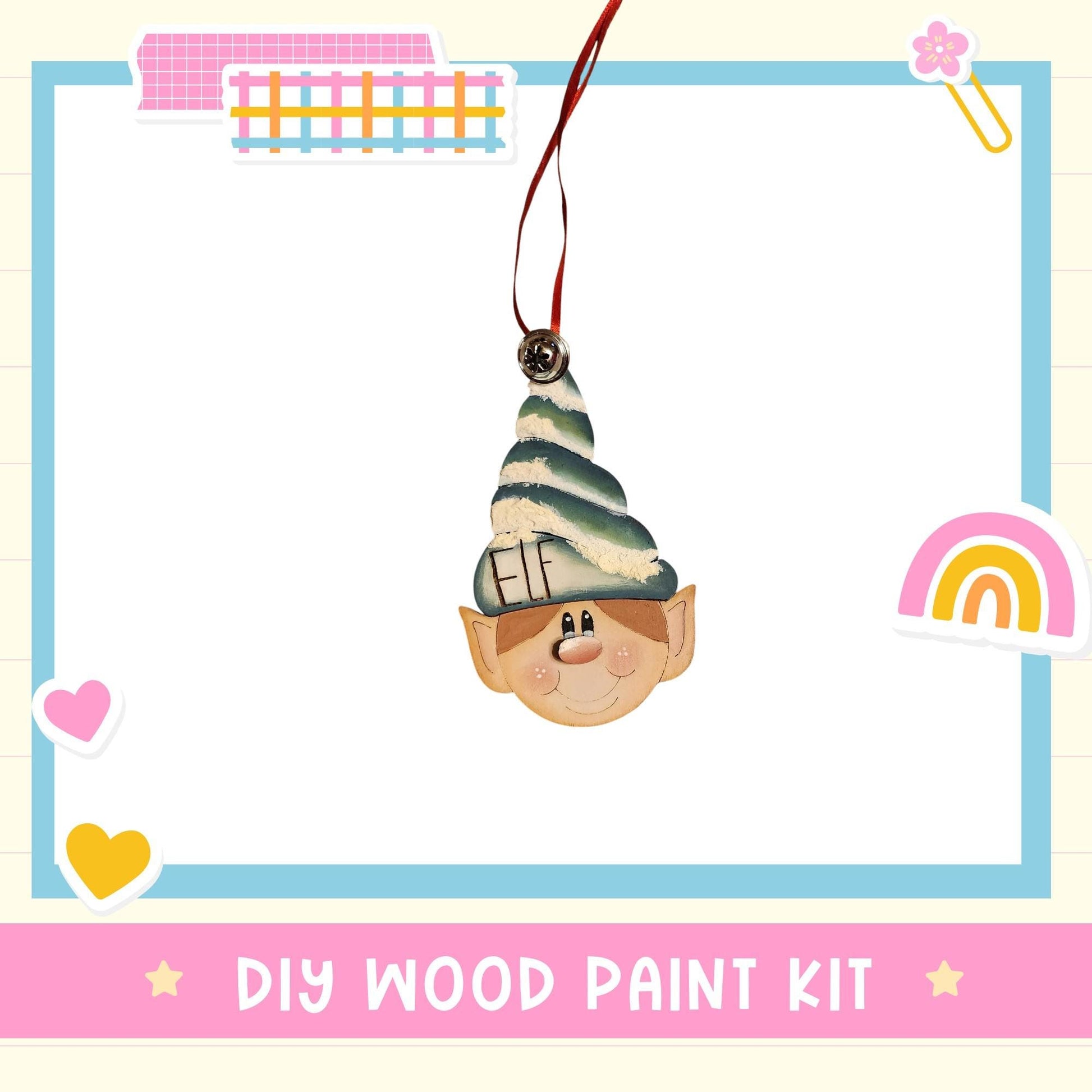 a DIY wood paint kit with a whimsical elf head ornament hanging from a string.