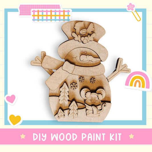 The image is a DIY wood paint kit featuring a wooden snowman with a hat, scarf, and other decorations.
