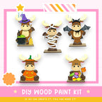 a DIY wood paint kit with five moose figurines dressed in various costumes, including a witch hat, a mummy, a bat, a pumpkin, and a candy cane.