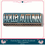 A wooden sign with the text "Hello Autumn" in a rustic farmhouse style, surrounded by a decorative border and flowers.