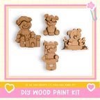 The image is a DIY wood paint kit featuring four wooden bear figurines in various poses, including one sitting on a bench and another holding a castle.