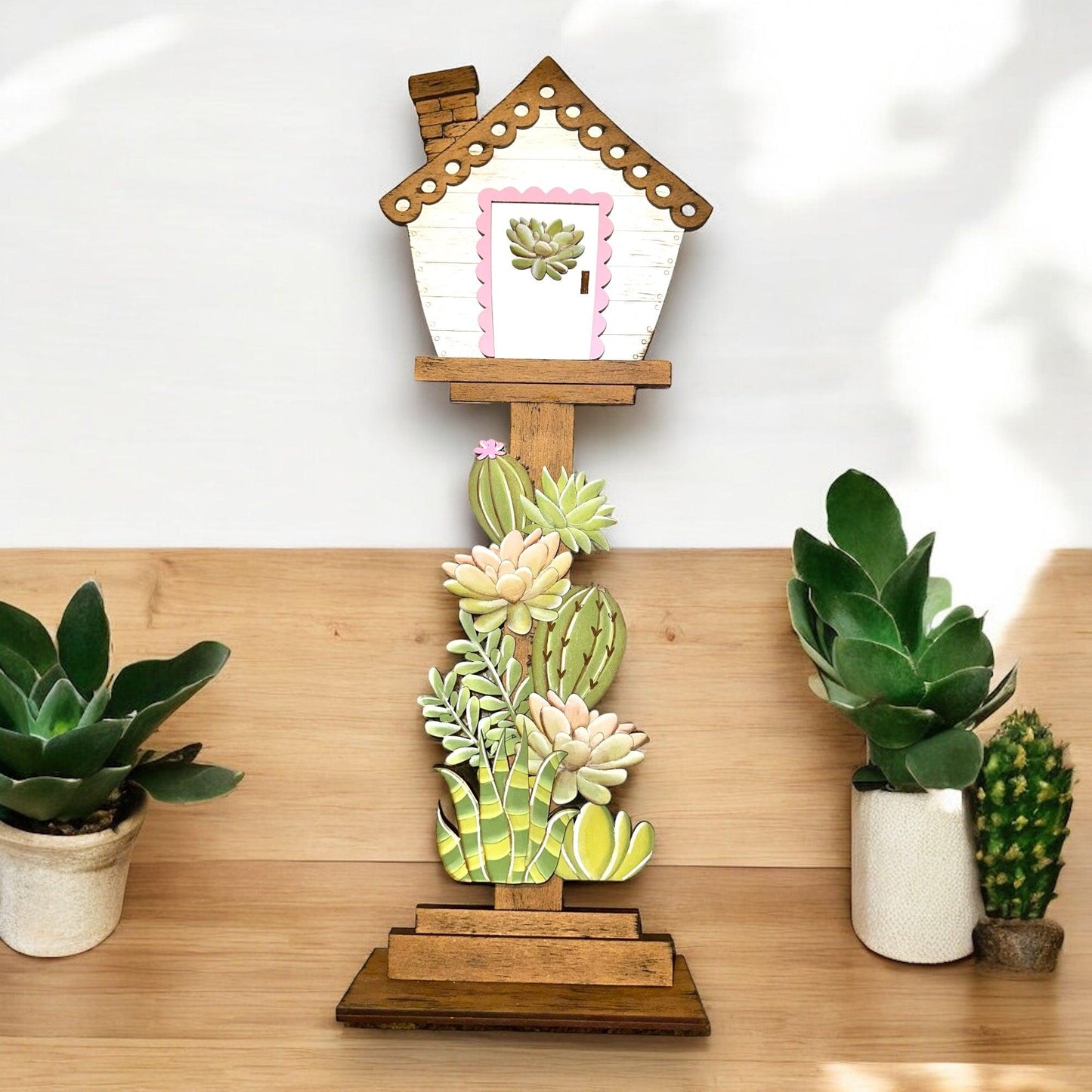 a house shaped planter sitting on top of a wooden table