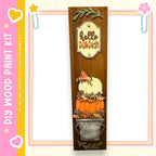 a wooden display with a pumpkin and leaves, along with a sign that says "Hello Pumpkin". The display is set against a pink and yellow background with a heart and star motif.