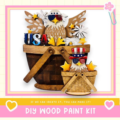 a DIY wood paint kit, with a wooden bucket and a smaller wooden basket containing various patriotic-themed decorations such as stars, flowers, and an eagle. The text "If we can create it, you can make it!" suggests that the kit is designed for individuals to create their own unique patriotic decorations.