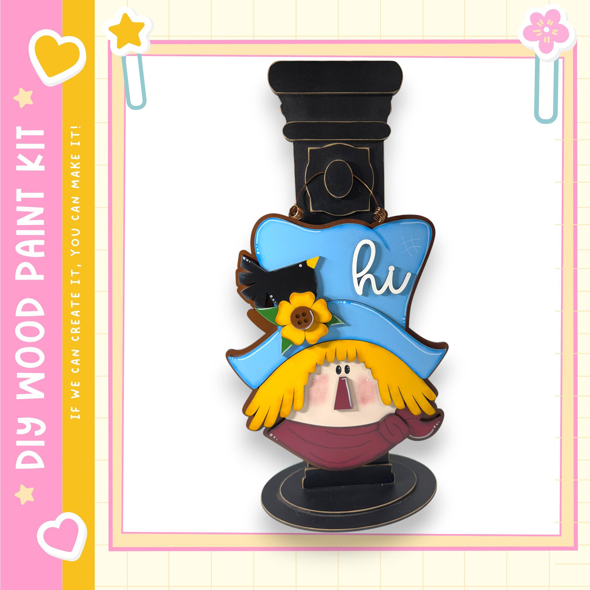 a wooden paint kit with a whimsical design, including a blue hat with a bird perched on it and a flower.