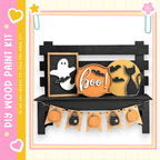 a Halloween-themed display with a black bench, a ghost, a cat, and a pumpkin. The bench has a sign that says "boo!" and a banner with pumpkins and bats hanging from it.