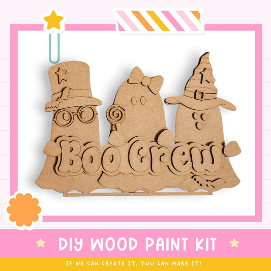 a DIY wood paint kit for creating a Halloween-themed decoration, including a wooden sign with the word "BOO CREW" and three cartoon-like ghost characters.