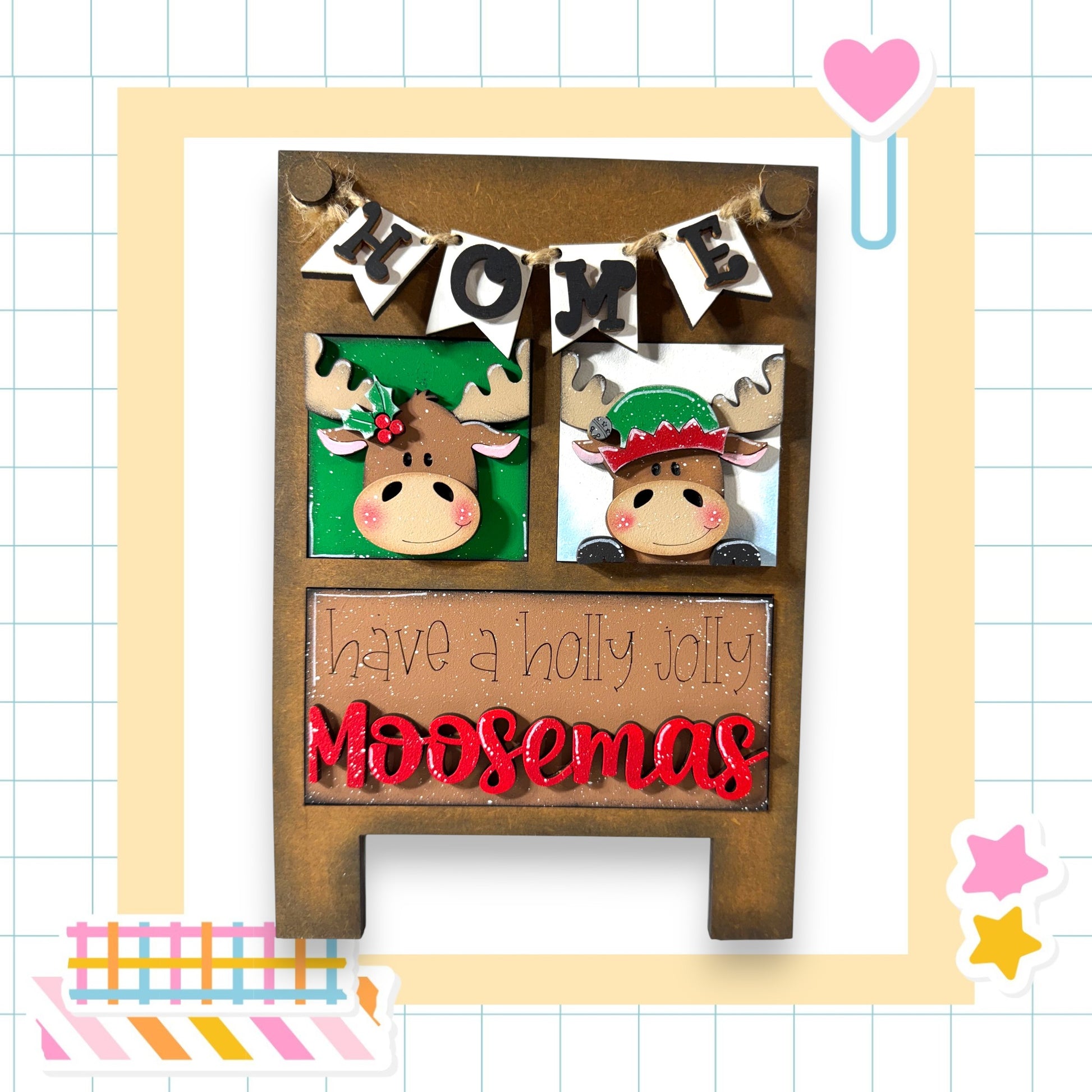 A wooden sign with moose heads and the text "Home" above them, along with the text "have a holly jolly Moosemas" below.