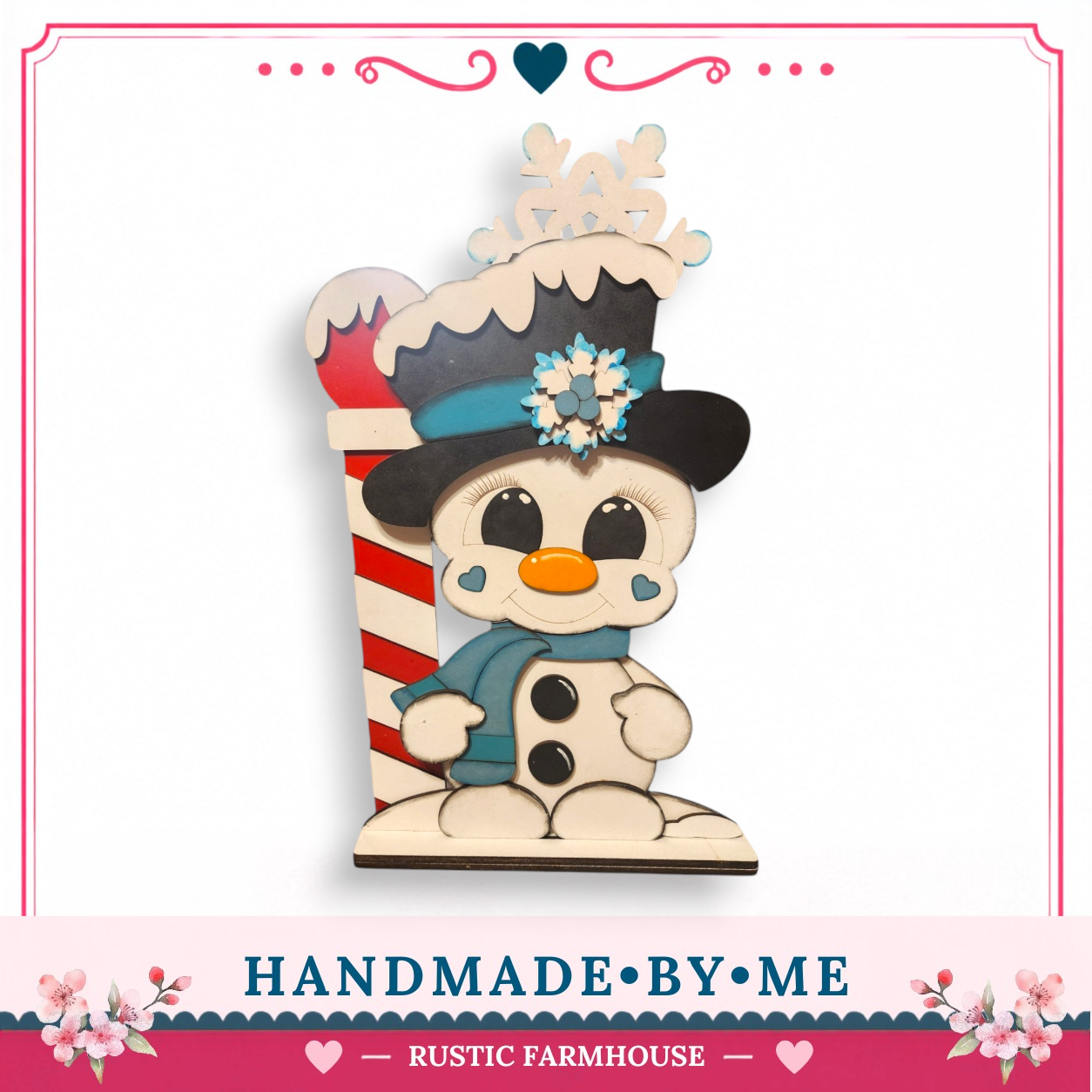 A hand-made wooden snowman figure with a red and white striped pole, wearing a black top hat and scarf, and a snowflake on its head, set against a white background.